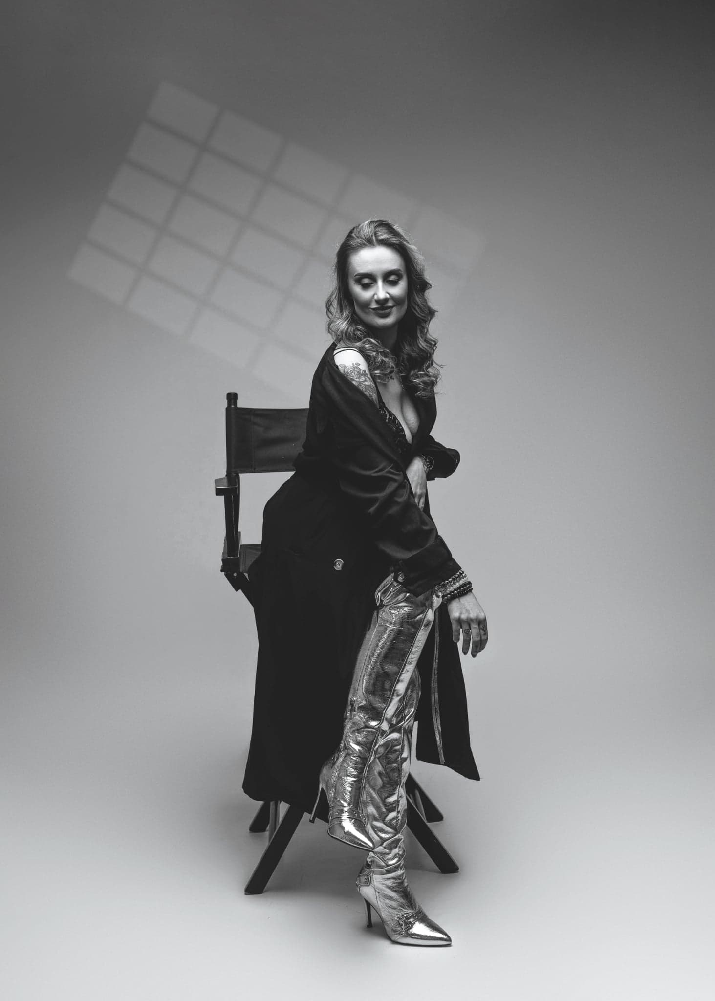 Karolina Gosz in a black and white chair editorial with metallic styling, sharp shadows and cinematic structure