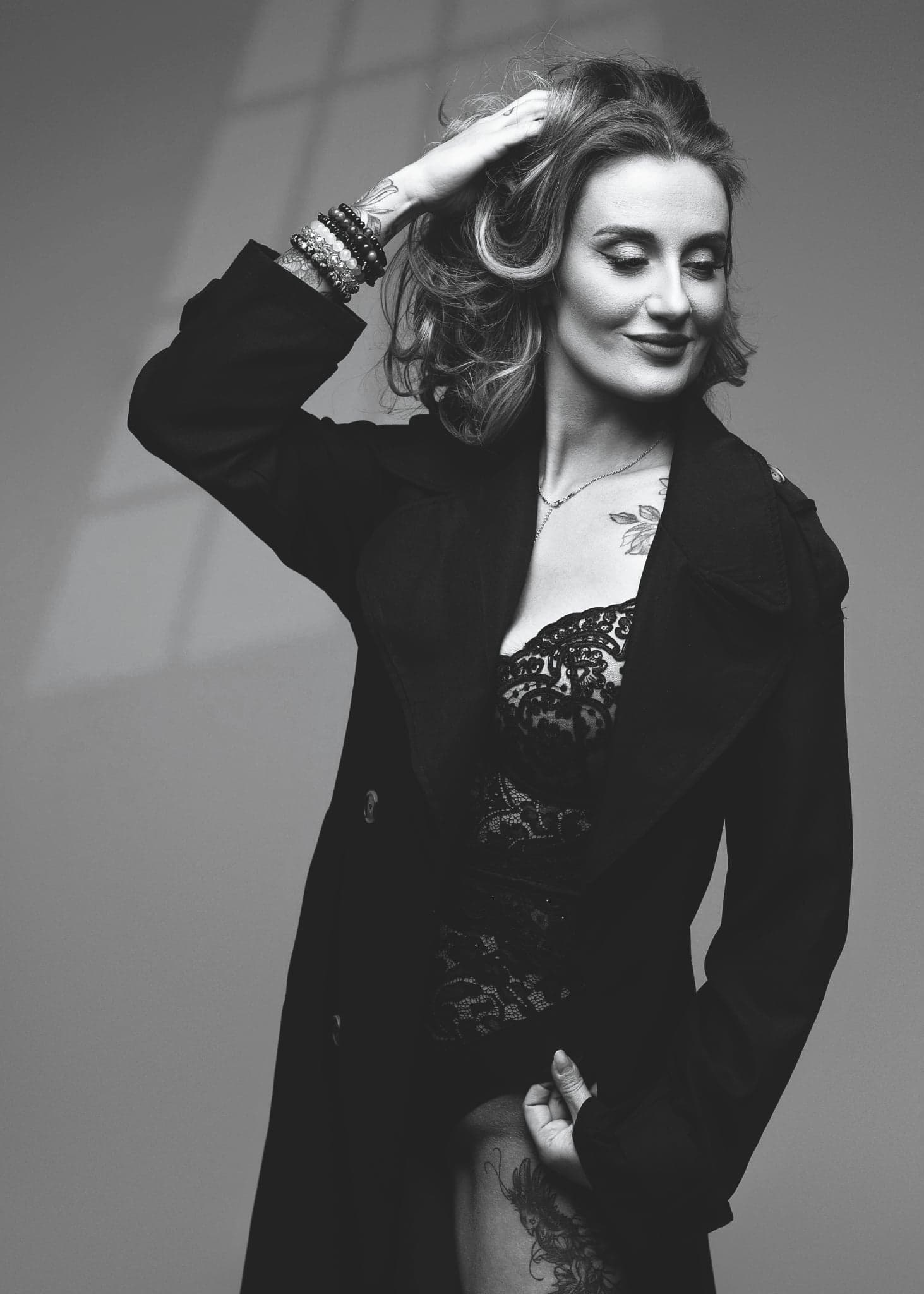 Karolina Gosz in a close monochrome noir portrait with a black coat, low-key lighting and focused intensity